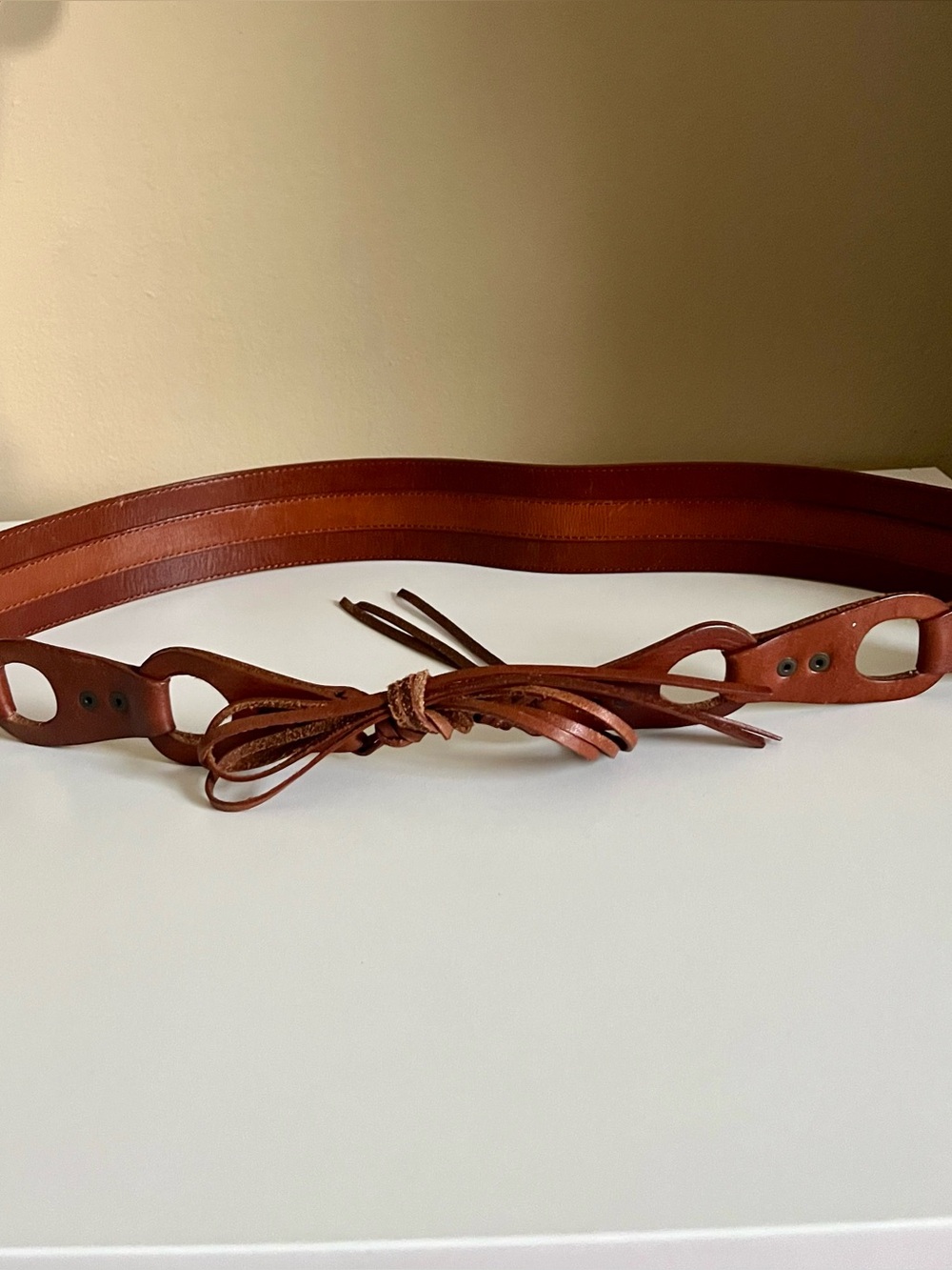 Interesting two-tone brown leather belt with cut out details and tie closure